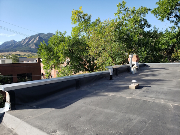 An antenna on the roof with Boulder Flatirons